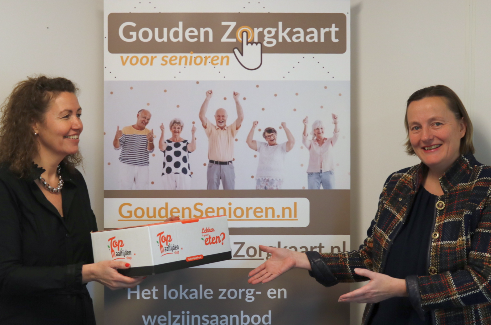 Joke Beekman, directeur TopMaaltijdenShop overhandigt maaltijdenbox aan Vera Verburgt, directeur Gouden Zorgkaart Nederland 